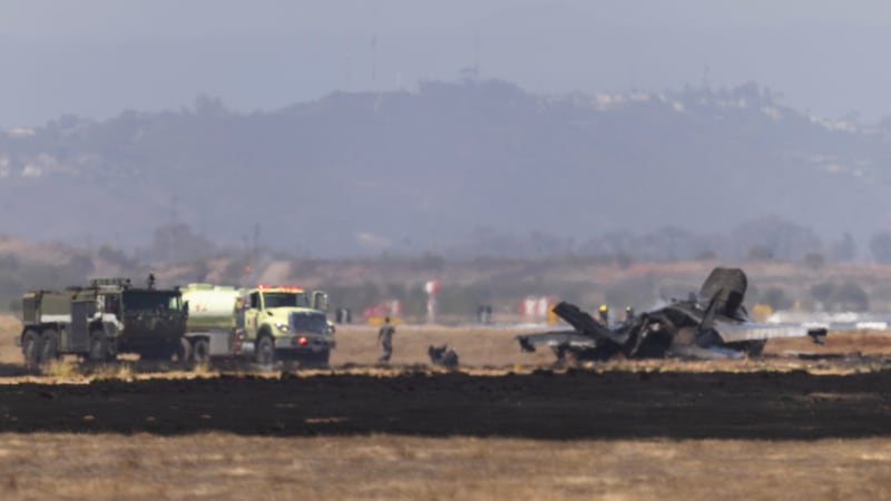 Crews work to douse a F-35 fighter jet that crashed near the run way at Marine Corps Air...