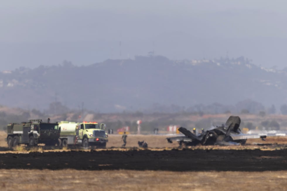 Crews work to douse a F-35 fighter jet that crashed near the run way at Marine Corps Air...